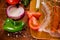 Above view of sausages inside of a plastic bags and vegetables, tomato, garlic, green pepper and onion and rosemary