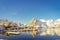 Above view of some wooden buildings in the bay with boats in the shore in Lofoten Islands surrounded with snowy