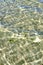 Above view of sunlight reflecting on water at beach. Closeup of shallow waves and calm ripples on coastline on sunny day