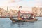 Abra Dhow wooden boat by RTA transport passengers wearing face masks from one bank of the Dubai