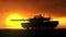 Abrams tanks against the setting sun.