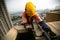 Abseiler inspector wearing yellow head fall protection safety helmet fall body harness, climbing over the edge