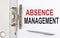 ABSENCE MANAGEMENT text on the paper folder with pen. Business concept