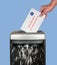 Absentee ballot of vote by mail envelope being shredded in an office shredder
