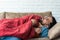 Absolute solitude. Side view of a depressed unhappy sad man lying on the sofa and hugging a blanket while feeling lonely, sad and