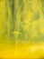 Abstract acrylic smoke under water. Close up view. Blurred background. Selective soft focus. Dropplets of yellow ink