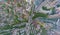Abstract aerial view of square in the city with traffic, streets and a lot of tall colored buildings with green trees with drop