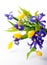 Abstract arrangement of purple irises, yellow tulips and mimosa on white background