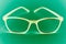 Abstract art closeup of isolated shiny eyeglasses with green background