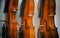 The abstract art design background of three violins stacked on background.show side of wood on violin,vintage and art style