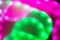 Abstract background of blurred neon green and pink lines.