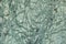 Abstract background in green tones of a piece of marble with dark green cracks