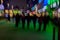 Abstract background. Intentional motion blur. Group of young people going along the street. Green shop window