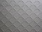 Abstract background of metal plate with diamond pattern painted grey close up.