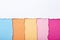 Abstract background of multi-colored stripes of torn cardboard lying vertically, top view