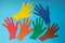 Abstract background open multicolored paper palms on a blue background.The concept of Autism Day and Youth Solidarity