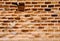 Abstract background with ragged ricketyold brick wall with crumbled bricks