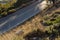 Abstract background transportation creative concept of car road shot from above with rocky and dry grass rocky surface of hill