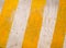 Abstract background, yellow diagonal strips on concrete weathere