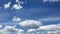 Abstract beautiful scenic timelapse of white fluffy clouds moving fast on clear blue sky line on bright sunny day