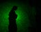 abstract black background with green color lasers and a woman figure silhouette.