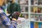 Abstract blurred background of a bookstore, hands of a man in protective gloves with a smartphone. Protection against viral