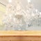 Abstract and blurred chrystal chandelier and elegant rustic wood table