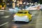 Abstract blurred evening traffic. Close-up of yellow taxi. Urban modern background