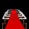 Abstract blurred image. Red carpet with stairs between two rope barriers and flash light. Scene illuminated by a spotlight.