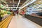 Abstract blurred supermarket aisle with colorful shelves and unrecognizable customers as background. Fruit and vegetable section