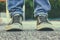 Abstract blurred urban background,low angle photo of pavement texture and person\'s shoes. selective focus