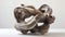 An abstract ceramic sculpture with multiple layers of twisted clay appearing to flow and intertwine seamlessly.