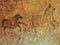 Abstract children art in sandstone cave. Black carbon paint of horses