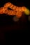 abstract Christmas lights vertical picture orange bokeh illumination from lamps on black background empty copy space for your text