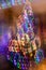 Abstract christmas neon background. Fancy Christmas tree with blurred vertical hanging glowing garlands