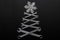 Abstract christmas tree made of wrenches with snowflake on the top on black background. Industrial christmas, winter, new year.