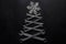 Abstract christmas tree made of wrenches with snowflate on the top on black background. Industrial christmas, winter, new year con