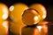 Abstract composition with beautiful, orange, transparent, round jelly balls on an aluminium foil with reflexions