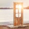 Abstract composition of a free-standing door in nature against the backdrop of a frozen lake in winter. The door to another world