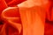 Abstract composition of orange synthetic fabric
