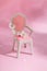 Abstract composition spring still life puppet chair with white flower on pink background