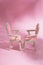 Abstract composition still life puppet chairs on a pink background with shadows