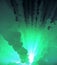 Abstract creative colorful background. Print. Source of green light with glowing rays. Underwater explosion with