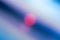 Abstract defocused blue background with bright pink spot in the center