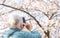 Abstract defocused and blurred of an elderly woman photograph beautiful cherry flowers blossom in a sunny spring day for