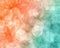 Abstract delicate blur bokeh background in peachy coral, minty teal, and shimmering bronze colors