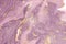 Abstract dusty violet liquid marble or watercolor background with gold glitter stripes and stains. Purple marble alcohol