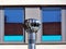 Abstract elevation view of stainless steel rotating exhaust vent in front of blue windows.