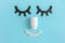 Abstract face made from closed decorative eyes, white bottle nose and pills mouth on blue background. Creative concept sleep,