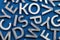 Abstract flat background of silver metal english alphabet characters on classic blue background.